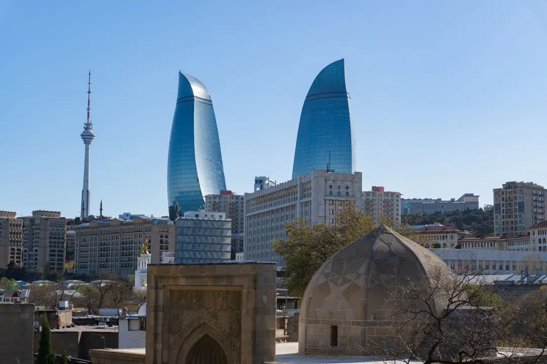 Skyline of Baku featuring iconic Flame Towers and telecommunications tower.