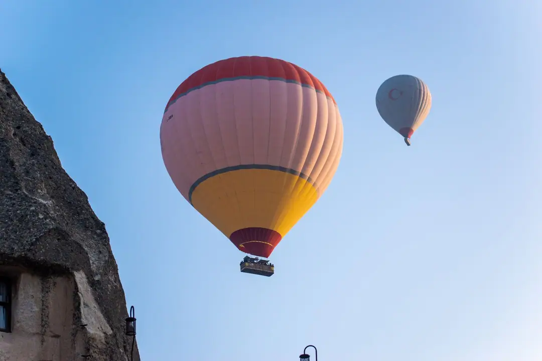 Two hot air balloons soar over a rocky landscape under a clear blue sky, capturing adventure and travel vibes.