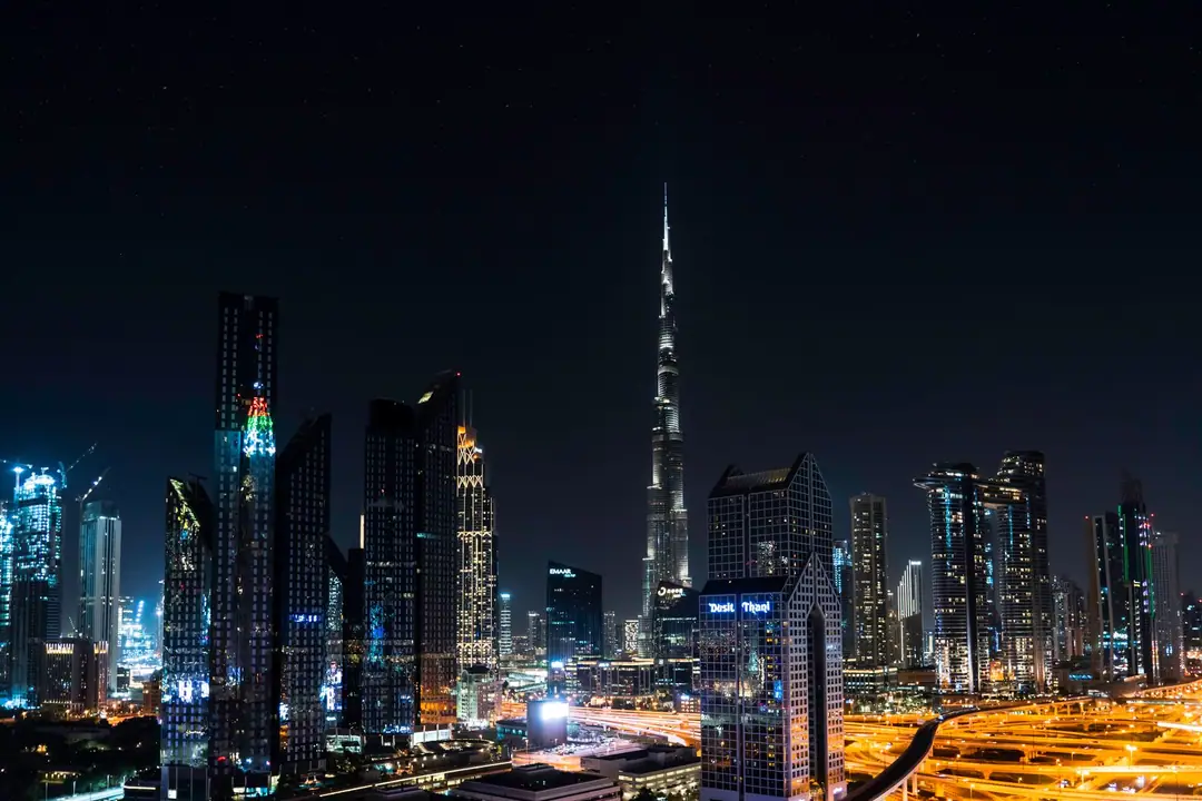 Stunning nighttime view of Dubai's skyline with the iconic Burj Khalifa illuminated under a starry sky.