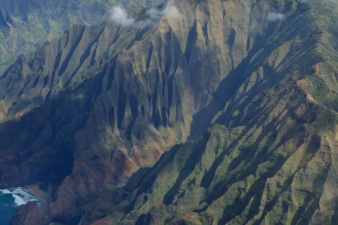Stunning aerial shot of the rugged Na Pali coast in Kauai featuring dramatic cliffs.