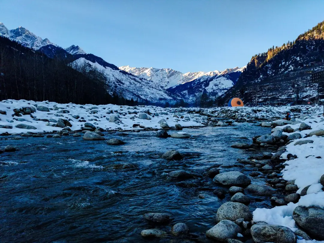 Beautiful snow-covered valley and river in Manali, India capturing the serene winter landscape.