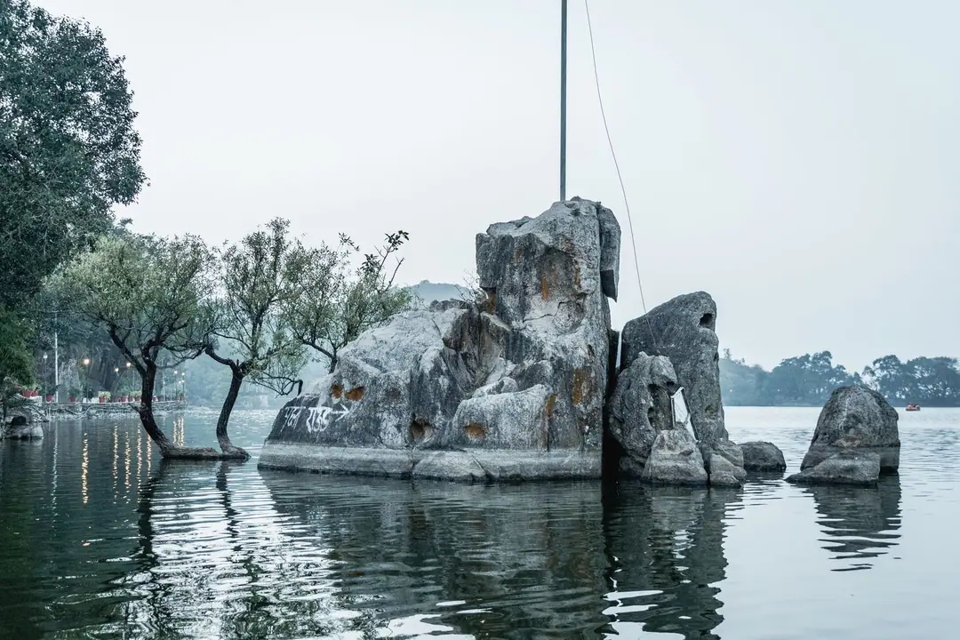 Beautiful rock formation and trees reflecting in a tranquil lake at Mount Abu, Rajasthan, India.
