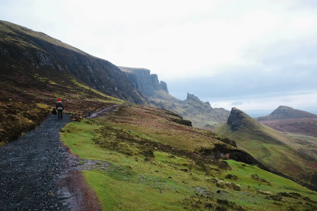 A scenic view of a hiker on a trail in Quiraing, Isle of Skye, Scotland.